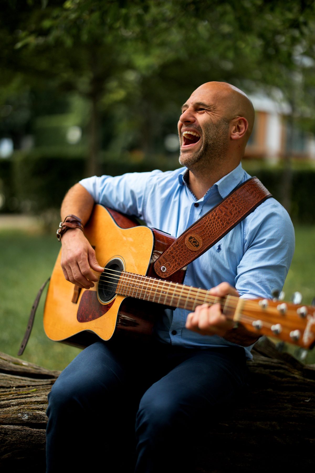 Barry de Jager playing acoustic guitar and laughing during a live session