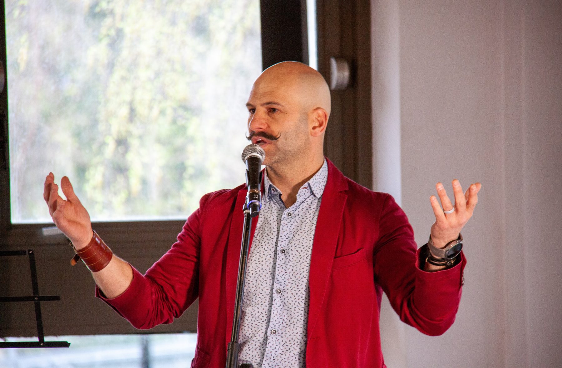 Barry de Jager speaking and performing on stage with a microphone